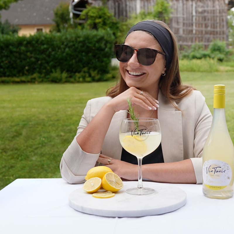 frau-trinkt-vintonic-laechelt-vintonic-lemonello-mit-zitrone-am-bild
